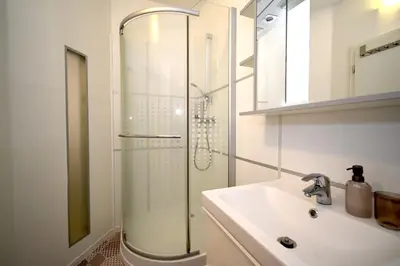 a bathroom with a glass shower and a sink at Central one bedroom apartment in Prague