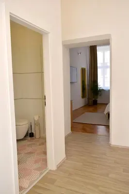 a room with a bathroom with a toilet and a hallway at Central one bedroom apartment in Prague