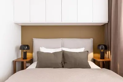a bedroom with a white bed with two lights above it at Modern studio with terrace in Prague