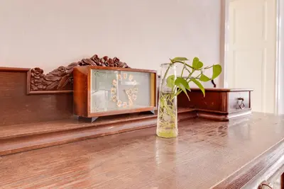 a table with a clock and a vase with a plant at Old Town Magical Stay Comfy 2BDR Historic House in Prague
