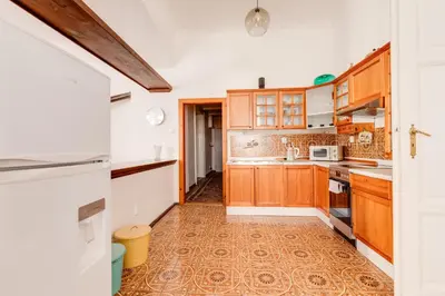 a kitchen with wooden cabinets and a tile floor at Old Town Magical Stay Comfy 2BDR Historic House in Prague