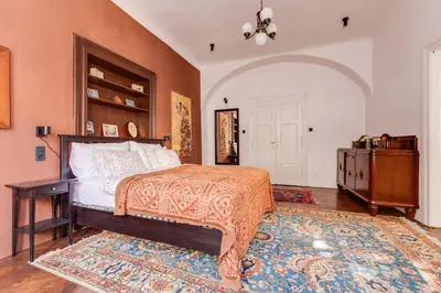 a bedroom with a bed and a table and a rug at Old Town Magical Stay Comfy 2BDR Historic House in Prague
