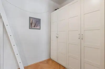 a white room with white cabinets and a staircase at Cozy 2 Bedroom Flat in Prague in Prague