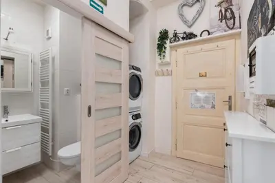 a bathroom with a washer and dryer next to a door at Cozy 2 Bedroom Flat in Prague in Prague