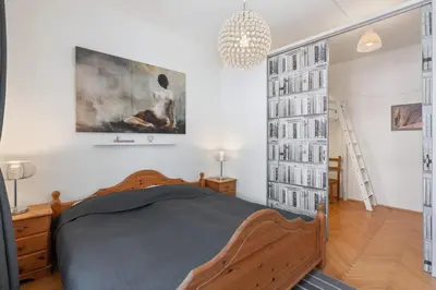 a bedroom with a wooden bed and a chandelier at Cozy 2 Bedroom Flat in Prague in Prague