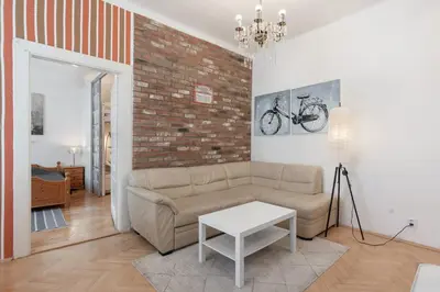 a living room with a couch and a brick wall at Cozy 2 Bedroom Flat in Prague in Prague
