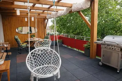 a patio with a swinging chair and a grill at Family, party Apartament in Prague