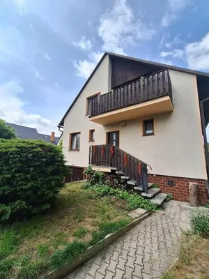 a house with a balcony on the side of it at Apartmány ŠTĚSTÍ in Bechlín