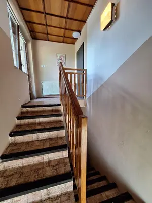 a stairway in a building with a wooden railing at Apartmány ŠTĚSTÍ in Bechlín