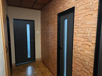 two doors in a room with a brick wall at Apartmány ŠTĚSTÍ in Bechlín