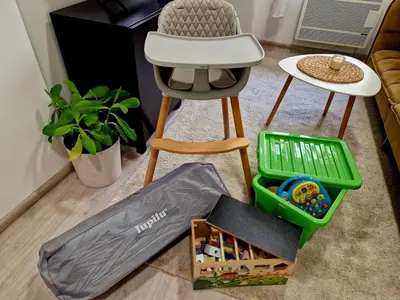 a chair and a table and a stool with toys at Apartmán Grébovka in Prague