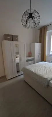 a bedroom with a bed and a chandelier at Apartmán Grébovka in Prague