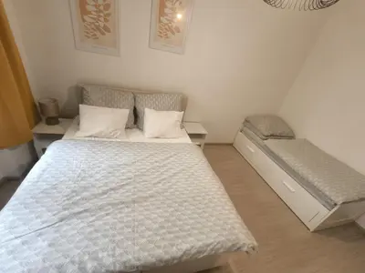 a bedroom with a bed and a bench in it at Apartmán Grébovka in Prague