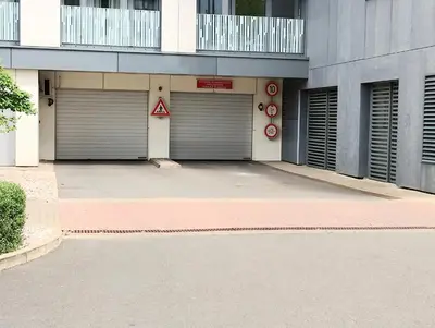 a building with two garage doors in a parking lot at Modern apartment with parking in Prague