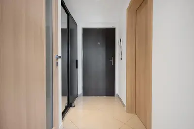 a hallway with a black door and a white tile floor at Modern apartment with parking in Prague