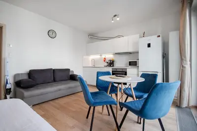 a living room with a table and chairs and a couch at Modern apartment with parking in Prague
