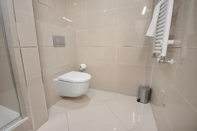 a small bathroom with a toilet and a shower at Modern apartment with parking in Prague