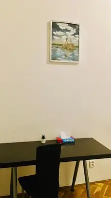 a table with a chair and a picture on the wall at Prague service Apartment - Central square location in Prague
