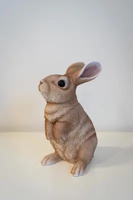 a small brown rabbit sitting against a white background at White Rabbit's Residence in Prague