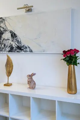 a shelf with a rabbit and a vase of flowers at White Rabbit's Residence in Prague