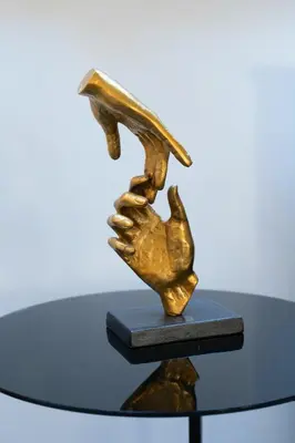 a bronze sculpture of a hand holding a bird at White Rabbit's Residence in Prague