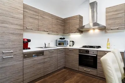 a kitchen with wooden cabinets and a microwave at White Rabbit's Residence in Prague
