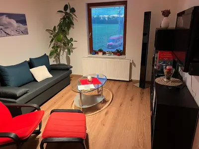 a living room with a couch and a glass table at Klidné ubytování u Prahy in Sluhy