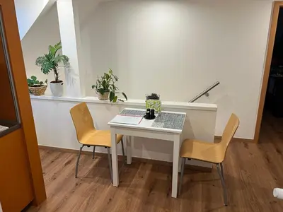 a table and chairs in a room with plants at Klidné ubytování u Prahy in Sluhy