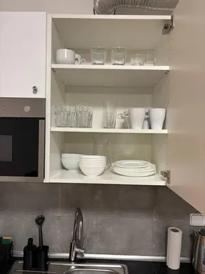 a kitchen cabinet with plates and bowls and a sink at Royal Stay Wenceslas Square in Prague