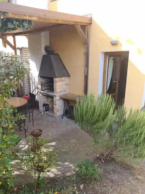 a patio with an outdoor grill with a table and chairs at Rodinný dům v Praze s bazénem in Prague