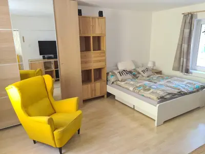 a bedroom with a bed and a yellow chair at Rodinný dům v Praze s bazénem in Prague