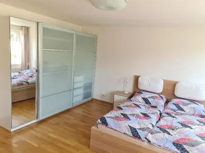 a bedroom with a bed and a glass closet at Rodinný dům v Praze s bazénem in Prague
