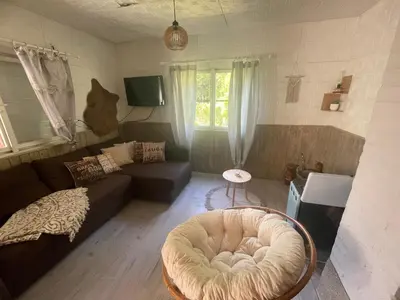 a living room with a couch and a chair at Chata Maruška na Sýkořici in Sýkořice