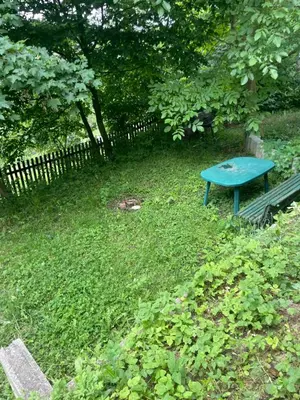 a blue bench sitting in the grass next to a fence at Chata Maruška na Sýkořici in Sýkořice
