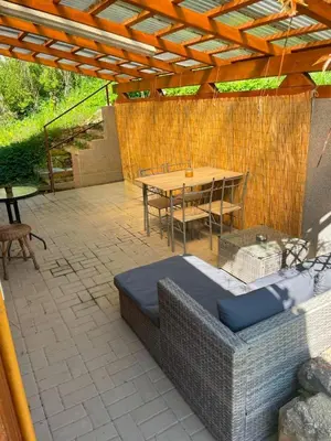 an outdoor patio with a table and a couch at Chata Maruška na Sýkořici in Sýkořice