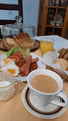 a table with a plate of breakfast food and a cup of coffee at Apartmán Libochovice in Libochovice