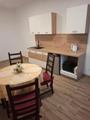 a kitchen with a table and two chairs and a counter at Apartmán Libochovice in Libochovice