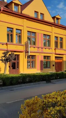 a yellow building with a sign in front of it at Apartmán Libochovice in Libochovice