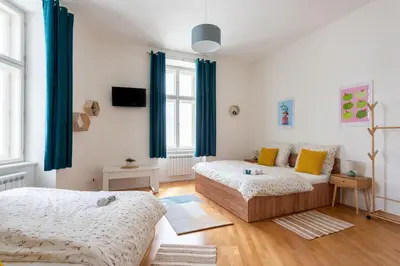 a bedroom with two beds and a couch at Central City Apartments in Prague