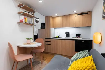 a living room with a couch and a table and a kitchen at Central City Apartments in Prague