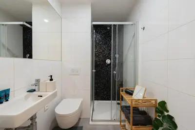 a bathroom with a shower and a toilet and a sink at Central City Apartments in Prague