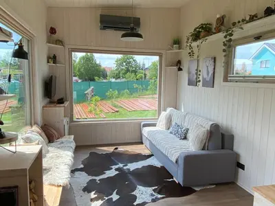 a living room with a couch and a large window at Tiny House in Stará Boleslav