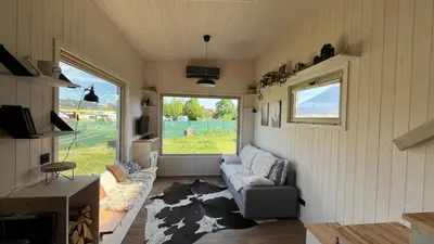 a living room with a couch and a large window at Tiny House in Stará Boleslav