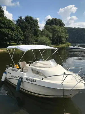 a white boat is sitting in the water at Apartmán Slapy - Ždáň in Slapy