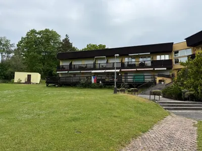 a building with a grass field in front of it at Apartmán Slapy - Ždáň in Slapy