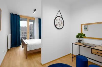 a bedroom with a bed and a desk and a window at Stylish Flat by the Metro in Prague