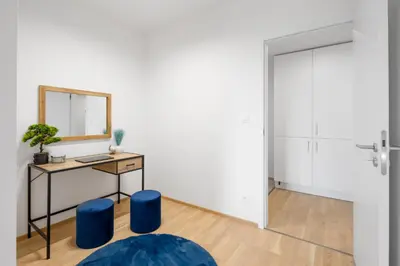 a room with a mirror and a table with blue stools at Stylish Flat by the Metro in Prague