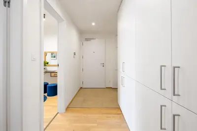 an open hallway with white walls and a door to a room at Stylish Flat by the Metro in Prague