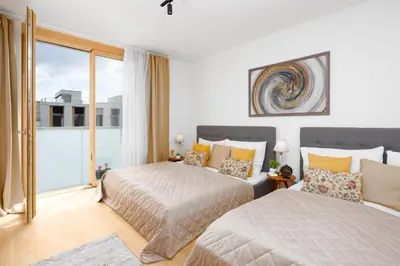 a bedroom with two beds and a large window at Stylish Flat by the Metro in Prague