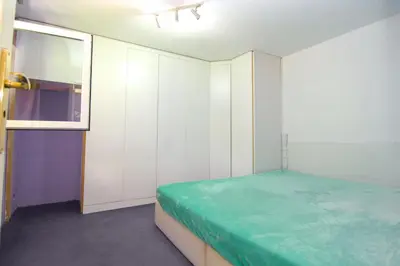 a bedroom with white cabinets and a green bed at Oáza klidu v Březové in Březová